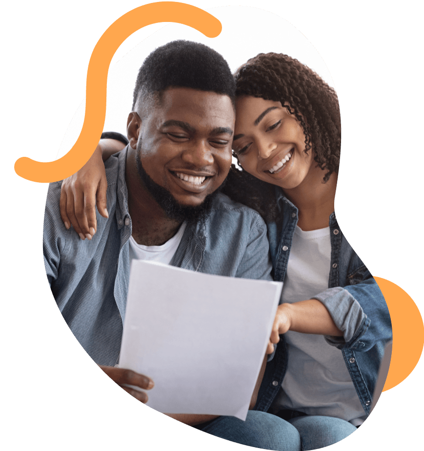 A photograph of a couple smiling whilst checking some documents.